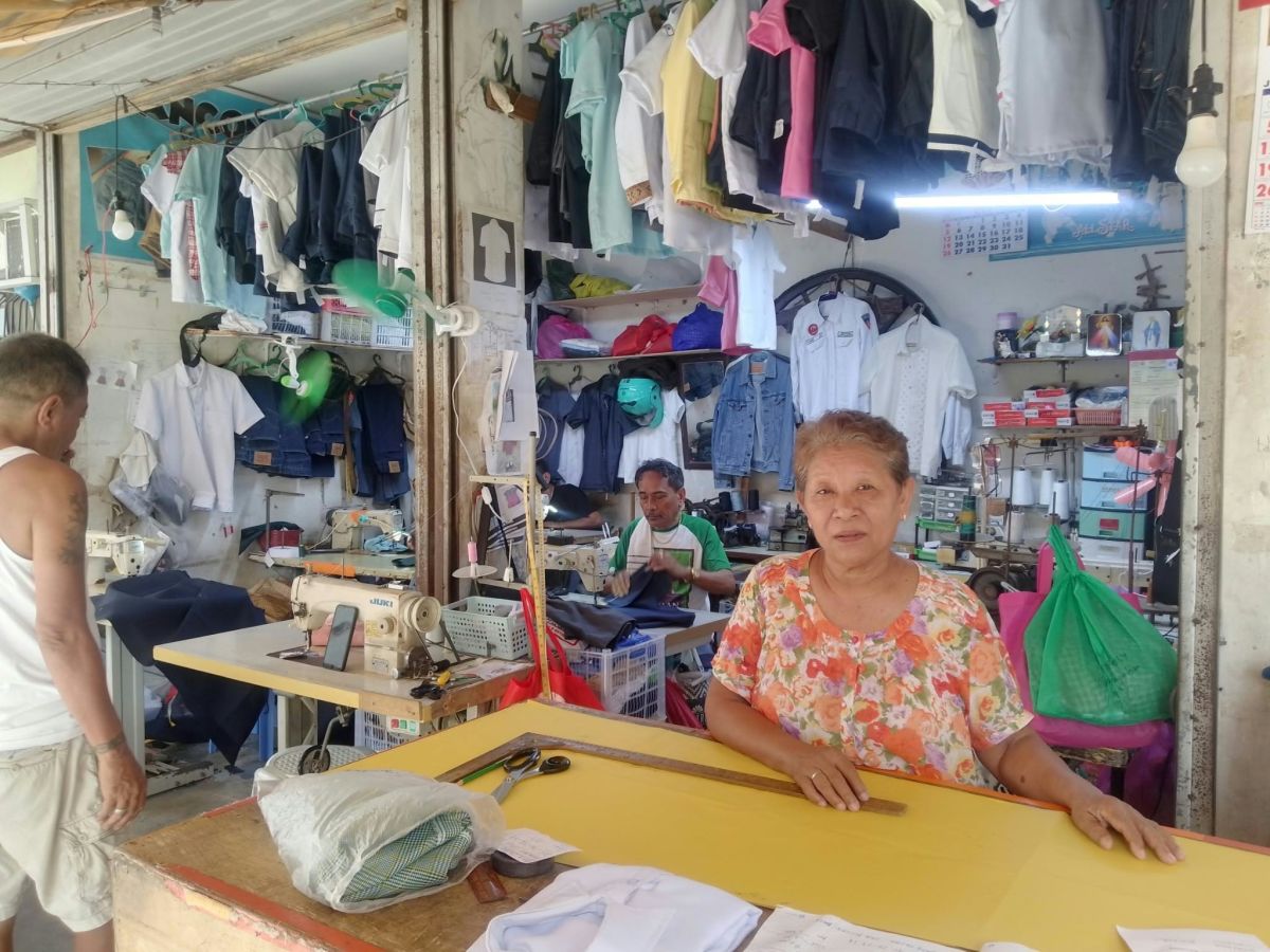 Susan at the counter of her sewing workshop in the Philippines