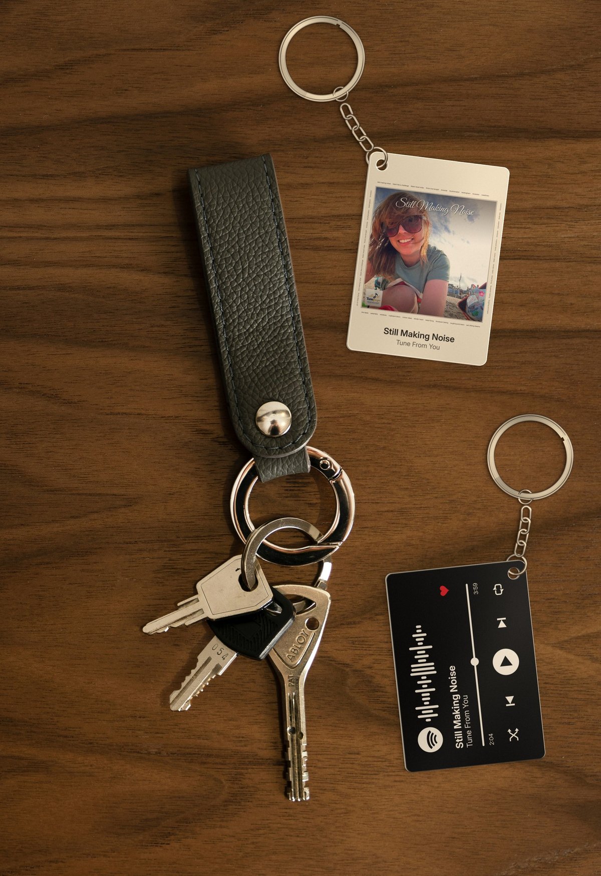 Personalised metal Spotify keyring showing cover art on the front and a Spotify-player style back with scannable code
